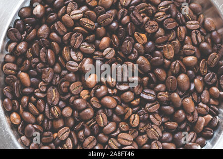 I chicchi di caffè in una ciotola di metallo Foto Stock