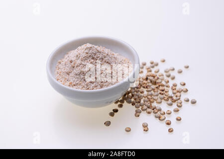 Non cotti materie Sorgo Farina (noto anche come sorgo) in una ciotola bianco, isolato su sfondo bianco Foto Stock