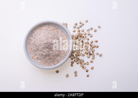 Non cotti materie Sorgo Farina (noto anche come sorgo) in una ciotola bianco, isolato su sfondo bianco Foto Stock