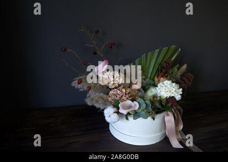Una scatola con un bouquet vintage su uno sfondo scuro, il fuoco selettivo Foto Stock