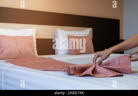 Hotel cameriera pulizia servizio in camera da letto. Foto Stock