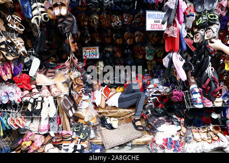 TAYTAY, Rizal, Filippine - 7 Novembre 2019: conveniente assortiti di abbigliamento e calzature sul display in un bazar stallo a un famoso bazaar luogo o loca Foto Stock