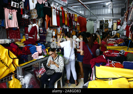 TAYTAY, Rizal, Filippine - 7 Novembre 2019: conveniente assortiti di abbigliamento e calzature sul display in un bazar stallo a un famoso bazaar luogo o loca Foto Stock