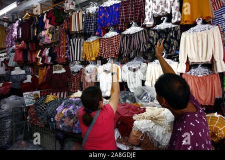 TAYTAY, Rizal, Filippine - 7 Novembre 2019: conveniente assortiti di abbigliamento e calzature sul display in un bazar stallo a un famoso bazaar luogo o loca Foto Stock