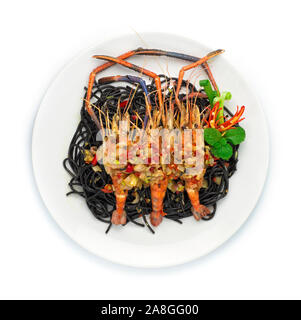 Spaghetti al nero di cibo piccante servita con i gamberi alla griglia cibo tailandese miscelati Italiano in stile fusion decorare con peperoncino intagliato e cipolline vista superiore Foto Stock