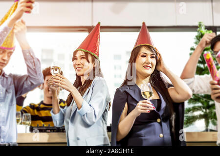 Il team di Business celebrando con champagne e parte di corna in ufficio. Foto Stock