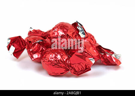 I dolci al cioccolato avvolto in un foglio di alluminio contro uno sfondo bianco Foto Stock