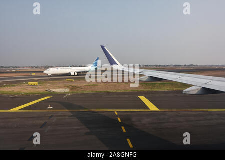 Vista del paesaggio, angolo di foto da finestra aereo,Airbus A320, l'ala sinistra, Garuda Indonesia Boeing 737 series, in rullaggio per il decollo Foto Stock