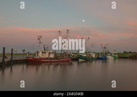 Barche da pesca al crepuscolo nel porto di Dornumersiel, Frisia orientale, Mare del Nord, Germania Foto Stock