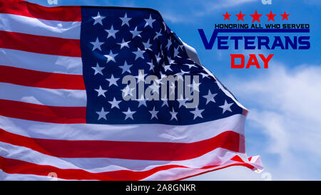 Felice giorno veterani con bandierine americane sul cielo blu sullo sfondo. Foto Stock