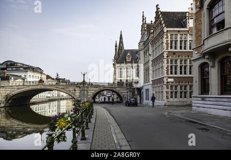 GHENT, Belgio - 05 settembre 2018: Vecchia casa di mattoni con rilievi sulla parete e piccolo negozio con porta rossa con i clienti su Settembre 05, 2018. Foto Stock