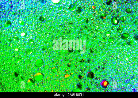 Colorato gocce di olio sull'acqua. Colore verde cerchi, ovali. Abstract sfondo luminoso per la progettazione. Foto Stock