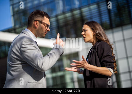 Colleghi di lavoro che stanno sostenendo al di fuori dell'edificio dell'azienda. Foto Stock