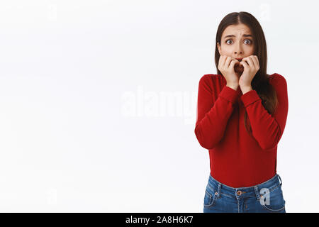 Spaventata innocente giovane ragazza timida in rosso maglione, spaventati e senza  parole da paura, mordere le unghie, guardare fotocamera stupified con  vittima Foto stock - Alamy