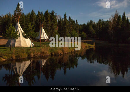 Due tende Tepee Teepee davanti un lago di notte, Domaine Notcimik : 13 Ottobre 2019 - La Bostonnais, Québec, Canada Foto Stock