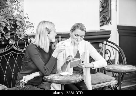 Miglioramento di auto e l'istruzione. Discutendo popolare libro best-seller. Letteratura femminile. Prenota ogni ragazza dovrebbe leggere. Ragazze amici seduti cafe terrazza Foto Stock