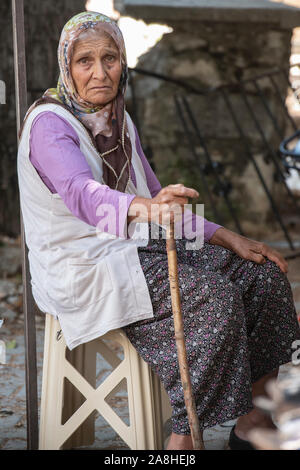 Un triste guardando anziana signora con piercing occhi verde vivere una semi uno stile di vita nomade in un villaggio in Turchia Foto Stock