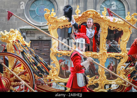 City of London, Londra, Regno Unito, 09 novembre 2019. Il 692nd Sindaco di Londra, Assessore William Russell, onde dal Golden State pulmann al Guildhall come egli set off. Il Signore annuale del sindaco, mostrano una parata attraverso la città di Londra che è 804 anni e questo anno presenta oltre 6000 partecipanti, vede Marching Band, distacchi militare, carrelli, di compagnie di danza, gommoni e molti altri fanno il loro modo da Mansion House, via San Paolo alla Royal Courts of Justice. Credito: Imageplotter/Alamy Live News Credito: Imageplotter/Alamy Live News Foto Stock