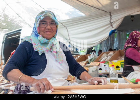 Una bella signora anziana prepara il cibo in una tenda in un villaggio in Turchia Foto Stock