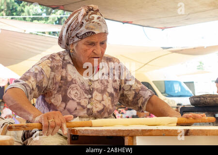 Una bella signora anziana prepara il cibo in una tenda in un villaggio in Turchia Foto Stock