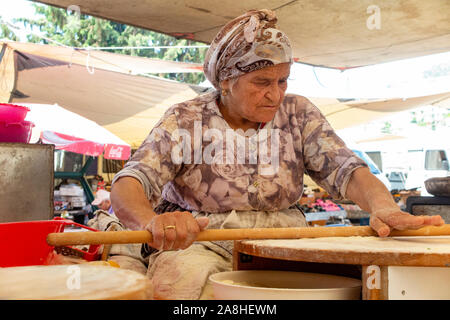 Una bella signora anziana prepara il cibo in una tenda in un villaggio in Turchia Foto Stock