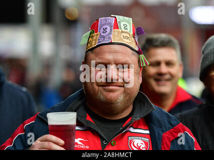 I fan di Gloucester sventolando il denaro falso e indossando tappi durante la Premiership Gallagher corrispondono al Kingsholm Stadium, Gloucester. Foto Stock