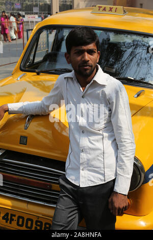 Indian taxi driver in posa davanti la sua cabina in Kolkata. La vettura è Hindustan Ambasciatore, fabbricati a partire dal 1958. Foto Stock