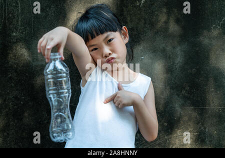 Bambino ragazza è azienda con bottiglia di plastica. Concetto per interrompere l'utilizzo di plastica. Foto Stock