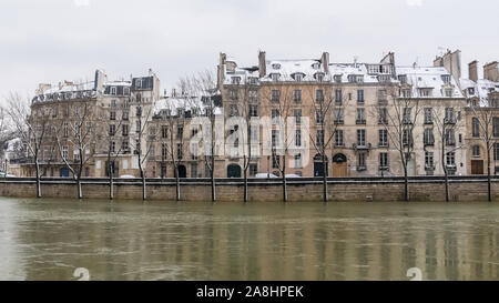 Parigi sotto la neve e le inondazioni, banchine allagate, alberi sotto l'acqua, la Senna in inverno Foto Stock