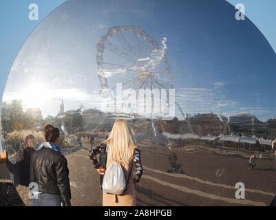 Guardare la gente di Győr Cityscape riflessione in Pulzus moderne sculture pubbliche sulla piazza Dunakapu Foto Stock