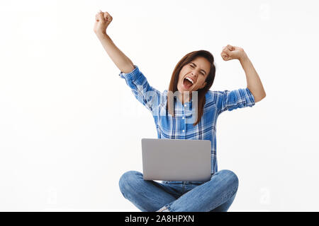 Lucky ambizioso spensierato di mezza età della donna di successo sente sollevato felice, urlando yeah sventolando in alto le mani del pugno di gesto della pompa, gridare urrà, finitura Foto Stock