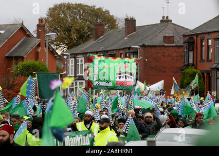 Rochdale, Regno Unito. 9 Novembre, 2019. Centinaia di prendere per le strade in un corteo per il mawlid al-Nabi, l osservanza del compleanno del profeta islamico Maometto. La processione è passata anche se il Deeplish e aree Milkstone prima di raggiungere il centro della città. Le rose sono stati consegnati in centro per gli acquirenti i passanti per celebrare sia Malid e nel ricordo di coloro che hanno dato la loro vita in guerre. Rochdale, Lancashire, Regno Unito. Credito: Barbara Cook/Alamy Live News Credito: Barbara Cook/Alamy Live News Foto Stock