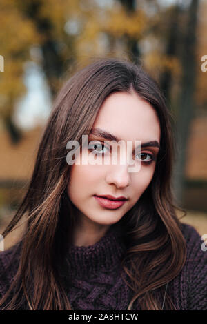 Close-up verticale di romantica bella giovane donna in autunno park. Foto Stock