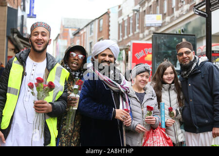 Rochdale, Regno Unito. 9 Novembre, 2019. Centinaia di prendere per le strade in un corteo per il mawlid al-Nabi, l osservanza del compleanno del profeta islamico Maometto. La processione è passata anche se il Deeplish e aree Milkstone prima di raggiungere il centro della città. Le rose sono stati consegnati in centro per gli acquirenti i passanti per celebrare sia Malid e nel ricordo di coloro che hanno dato la loro vita in guerre. Rochdale, Lancashire, Regno Unito. Credito: Barbara Cook/Alamy Live News Foto Stock