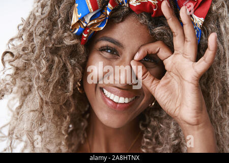 Attraente Headshot, spensierata giovane africano-american hipster donna bionda con acconciatura afro, usura fascia elegante, trafitto naso, mostrano bene gesto Foto Stock