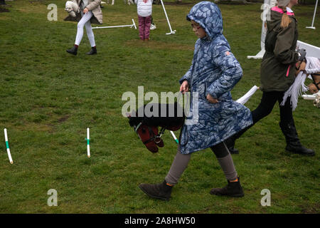 Mosca, Russia. 7 Novembre, 2019 partecipanti del Festival Hobbyhorsing nel club equestre "Izmailovo' durante la formazione prima del concorso di Mosca, Russia. Sport Hobbyhorsing simula tradizionali eventi equestri tra cui competono in dressage e show jumping dalla sella di un cavallo immaginario Foto Stock