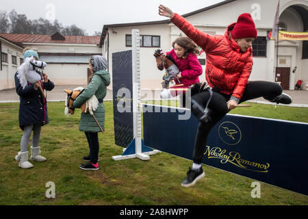 Mosca, Russia. 7 Novembre, 2019 partecipanti del Festival Hobbyhorsing nel club equestre "Izmailovo' durante la formazione prima del concorso di Mosca, Russia. Sport Hobbyhorsing simula tradizionali eventi equestri tra cui competono in dressage e show jumping dalla sella di un cavallo immaginario Foto Stock