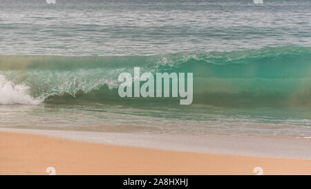 Onde che si infrangono su una spiaggia tropicale, belle acque turchesi e gocce Foto Stock