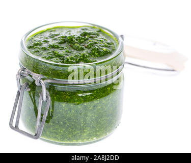 Pesto di aglio selvatico (Allium ursinum) e parmigiano in olio di oliva in un vetro trasparente isolato su sfondo bianco Foto Stock