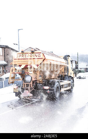 Un autocarro gritting viaggia attraverso la neve pesante gritting il pericoloso gelido e strade innevate. Black Ice, cattive condizioni della strada (Slow Shutter speed) Foto Stock