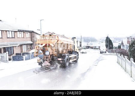 Un autocarro gritting viaggia attraverso la neve pesante gritting il pericoloso gelido e strade innevate. Black Ice, cattive condizioni della strada (Slow Shutter speed) Foto Stock