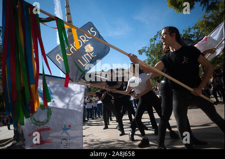 Un gruppo di ballerini con bandiere e membri dell'orchestra eseguire sulla strada durante una parata promozionali di 'un Chorus Line' musical diretto dallo spagnolo attore e regista Antonio Banderas, precedendo la premiere al Soho Caixabank teatro il 15 novembre 2019. 'Un Chorus Line" è il nuovo musical di Antonio Banderas circa un gruppo di danzatori provenienti da Broadway che fanno parte di un coro musicale. Foto Stock