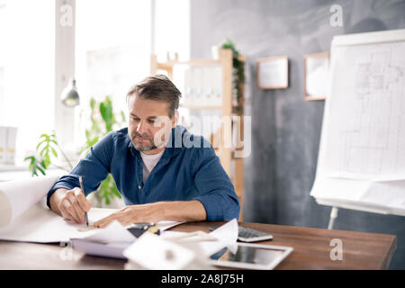 Architetto matura in informale disegno di linea sul piano mentre si effettua lo schizzo Foto Stock