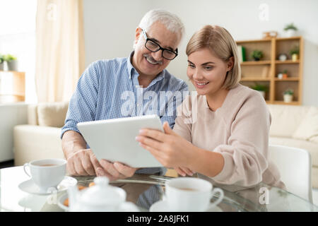 Felice di età compresa tra l uomo e la sua giovane figlia di parlare a qualcuno attraverso il video-chat Foto Stock