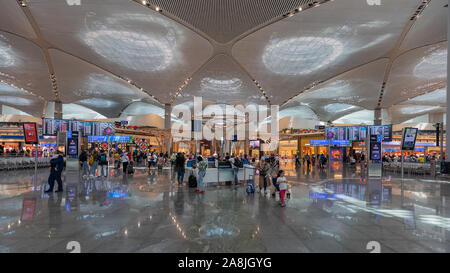 Istanbul, Turchia - 4 agosto 2019; la zona di transito su Istanbul Internatiol Airport edificio nuovo di zecca bella architettura molte riflessioni, spazio e paglierino Foto Stock