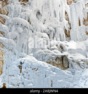 Ice Climber scaling congelati cataratta scende lungo il Rocky Mountain Front vicino a Augusta, montana Foto Stock