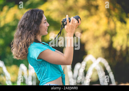 Ragazza sorridente in una città italiana con una macchina fotografica in mano. Foto Stock