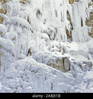 Ice Climber scaling congelati cataratta scende lungo il Rocky Mountain Front vicino a Augusta, montana Foto Stock