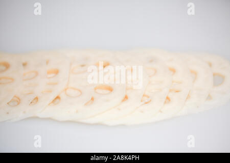 Fette di freschi lotus root su sfondo bianco - isolato (ingredienti asiatici) - Immagine Foto Stock