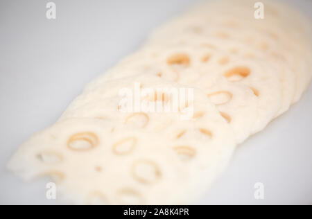 Fette di freschi lotus root su sfondo bianco - isolato (ingredienti asiatici) - Immagine Foto Stock